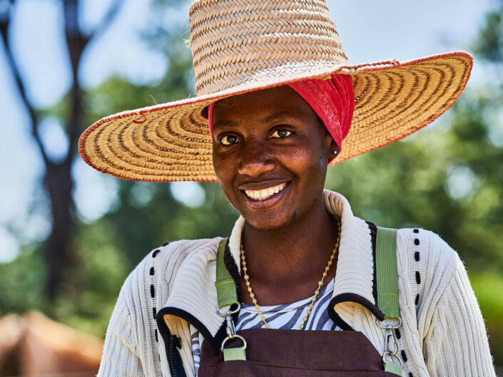 Lachende Frau mit großem Sonnenhut auf einer Kaffeeplantage in Tansania, Breiger, People Fotografie, Thilo Müller Photodesign, People Photography